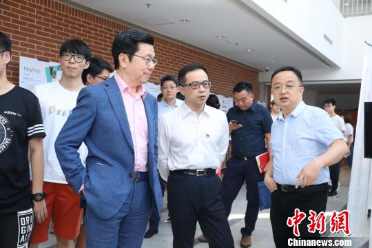 中关村管委会副主任翁啟文、创新工场董事长兼首席执行官李开复李开复等参观学员们的AI学习成果。　供图 摄